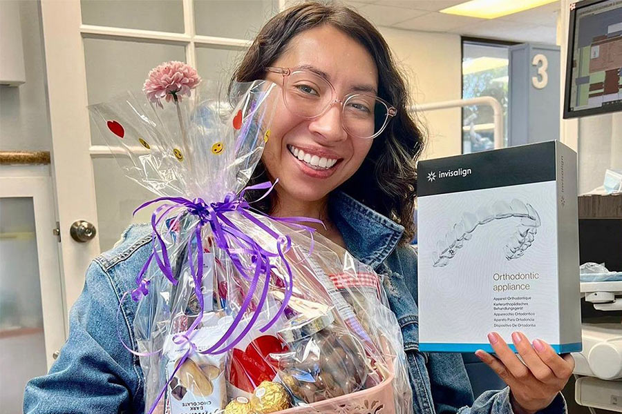 invisalign treatment patient smiling holding invisalign in dental office in montebello